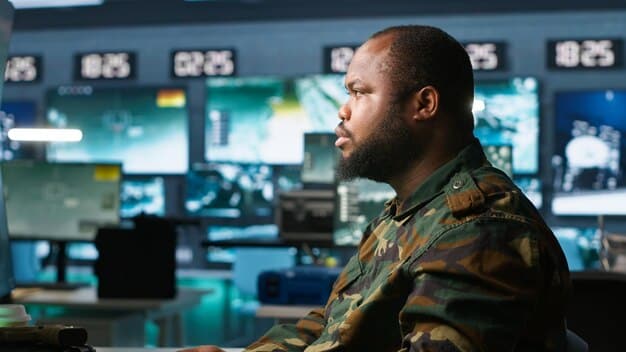 A photograph of a US military officer in a command center, looking at a large screen displaying real-time data analysis generated by an AI system. The officer appears to be evaluating the information to make strategic decisions.