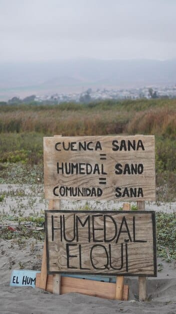 A photo depicting a crowded refugee camp in a developing nation, with signs indicating water scarcity and sanitation challenges, highlighting the humanitarian crises exacerbated by climate change and the potential strain on international resources.