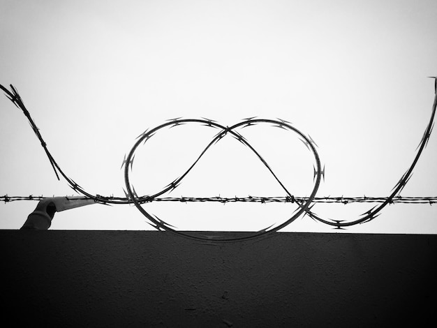 A split image showing the US flag on one side and the ICC logo on the other, with barbed wire visually separating them, symbolizing the divide and tension between the US and the court.